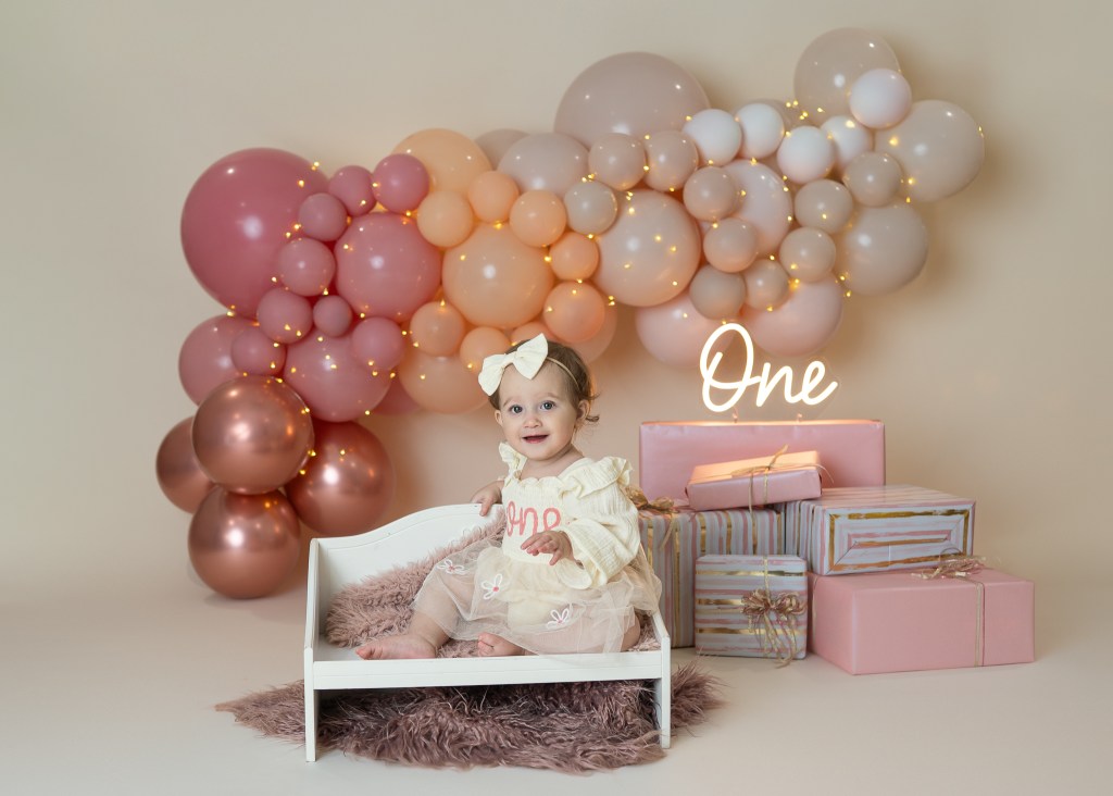 Sarasota upscale cake smash showing a baby posed before getting messy with her cake smash portion