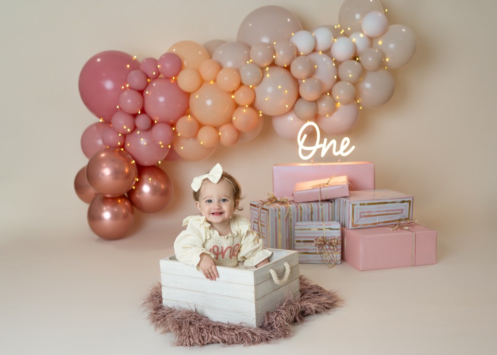 cute baby in a crate during her sarasota cake smash photo shoot