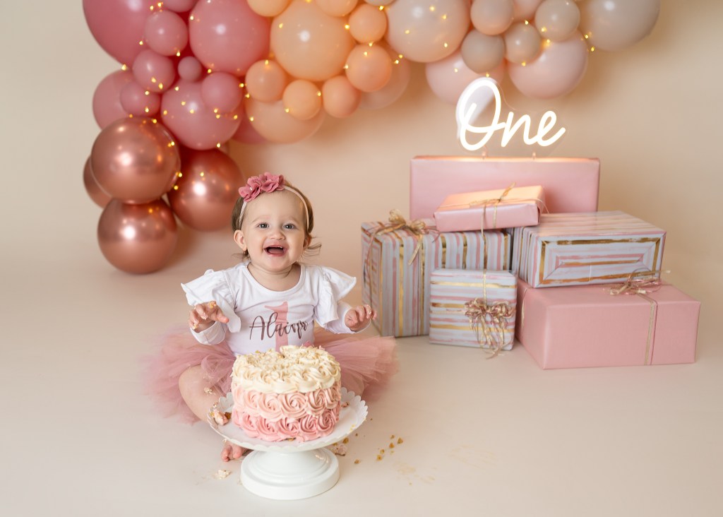Blush pink Cake Smash Session in Sarasota for baby girl with a custom-designed cake that was allergen friendly, free of toxic food dyes, and used maple sugar as a sweetener
