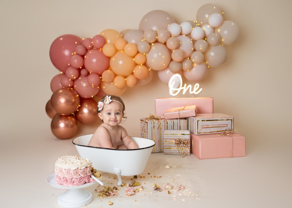 Baby girl enjoying the splash portion of her Sarasota upscale cake smash photo session