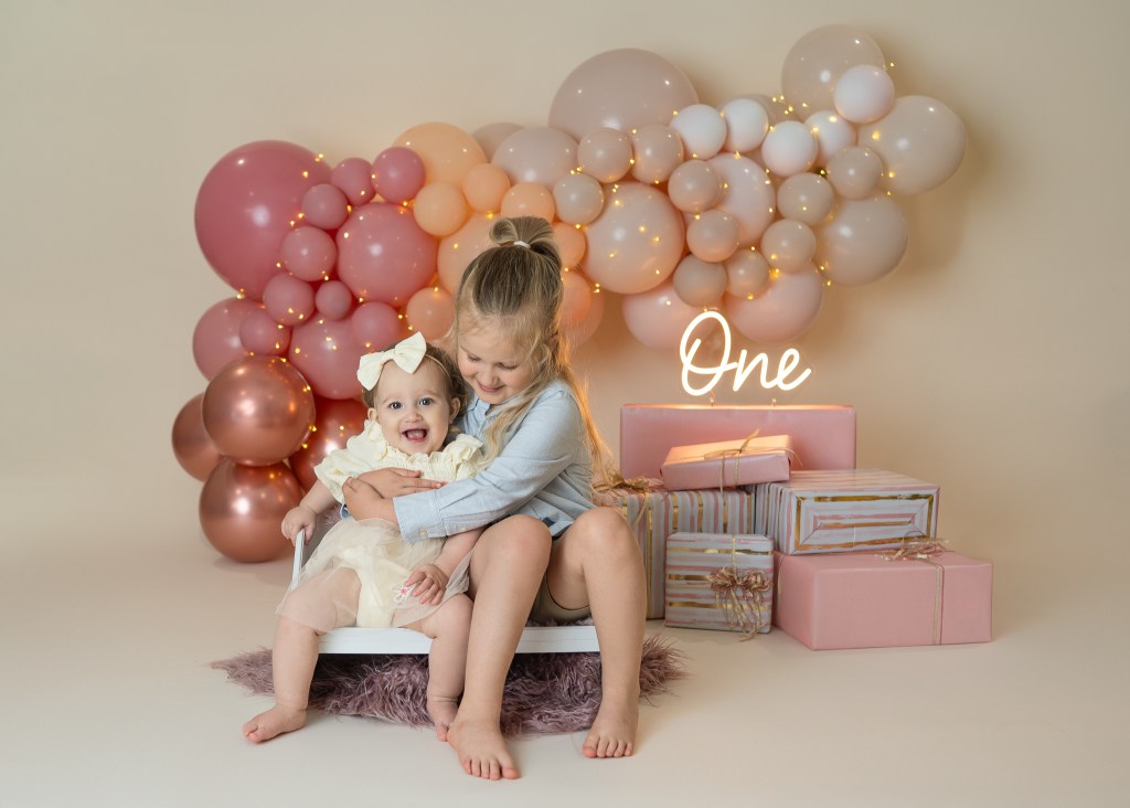 Big brother Avery gives baby sis Alaina a hug during her Sarasota family milestone photo session