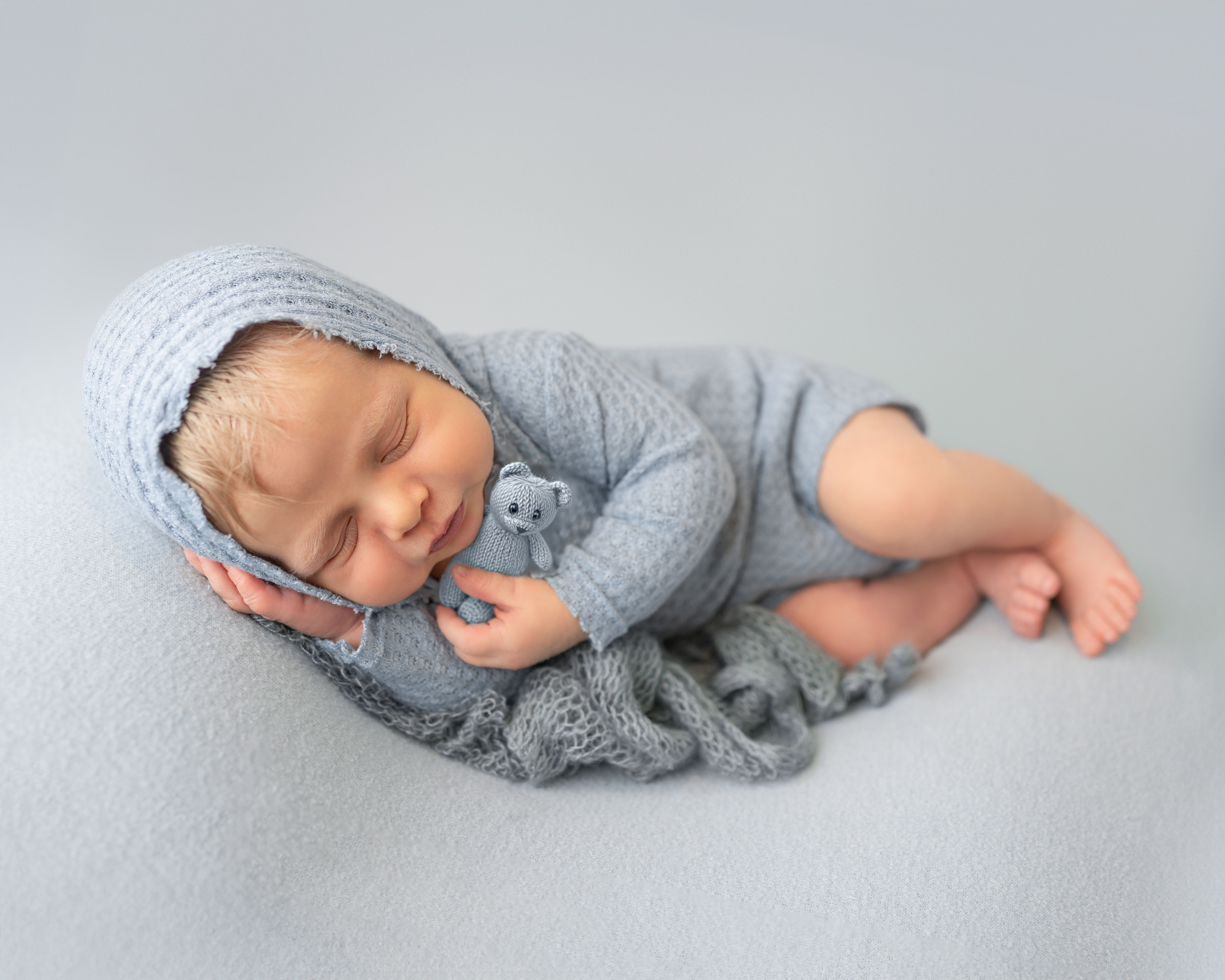 a sarasota baby newborn boy dressed in powder blue holding a teddy bear