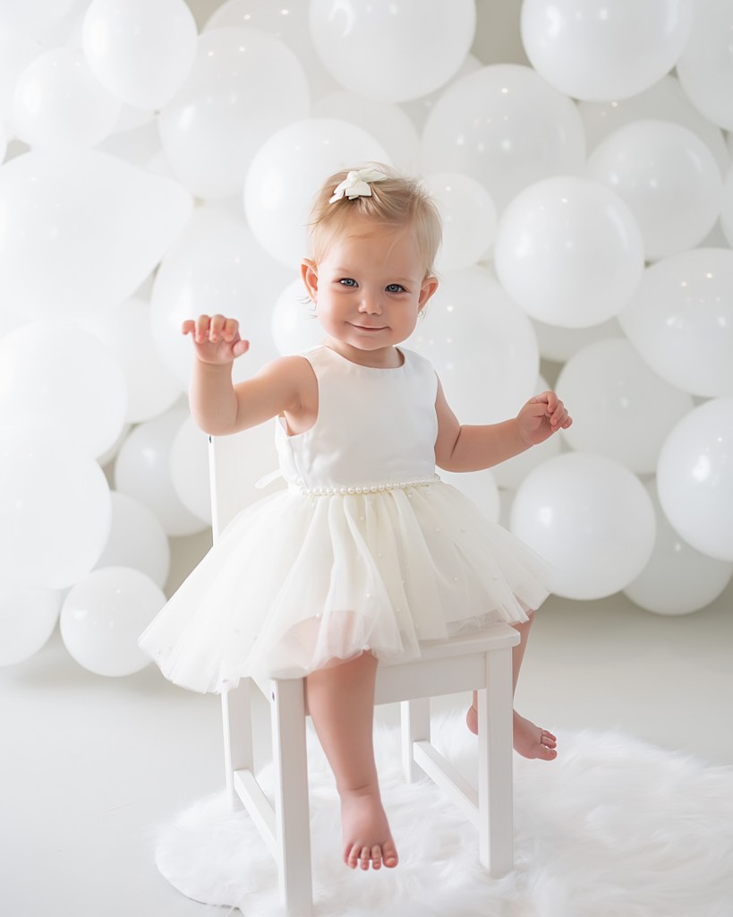 one year old girl dressed in white at her all white cake smash -Sarasota Family and Children’s Photographer