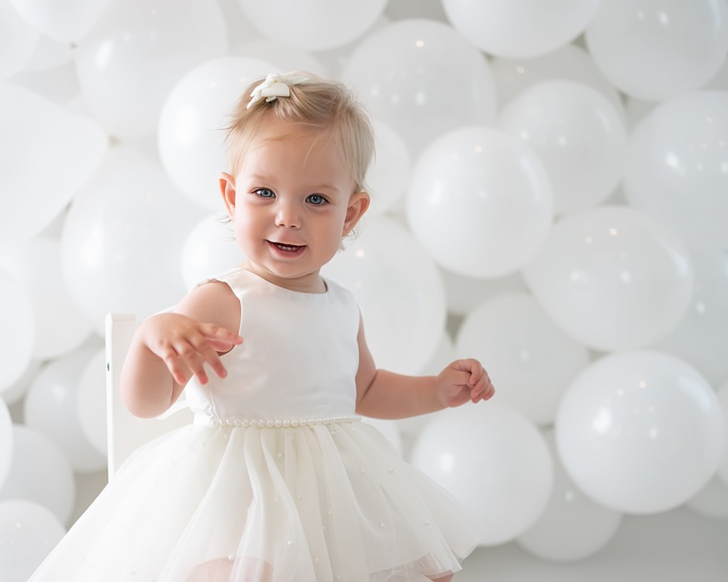 Baby smiling in front of balloon backdrop during a Sarasota photography session